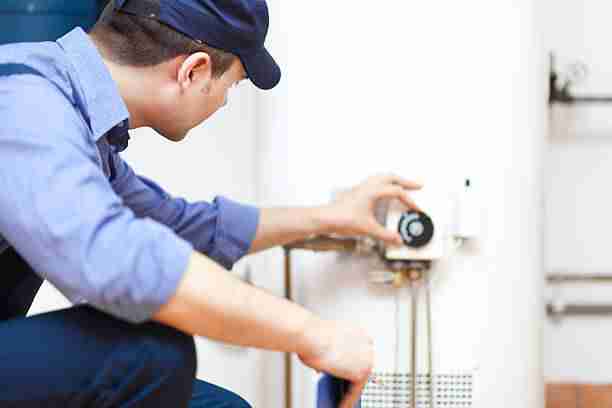 technician repairing an hot-water heater technician repairing an hot-water heater